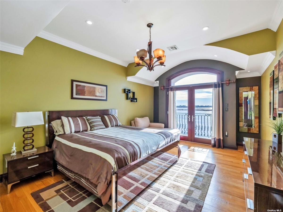 Bedroom with glass doors and a chandelier.