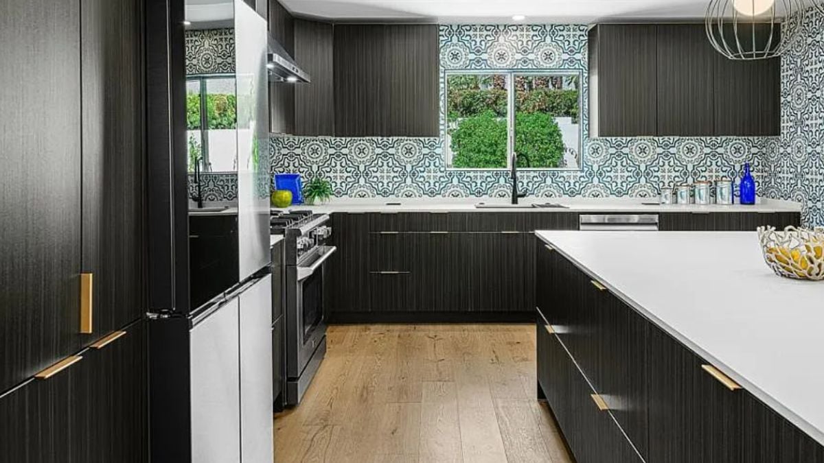 A kitchen with countertops, cabinets, a sink, kitchen appliances, and accent walls.