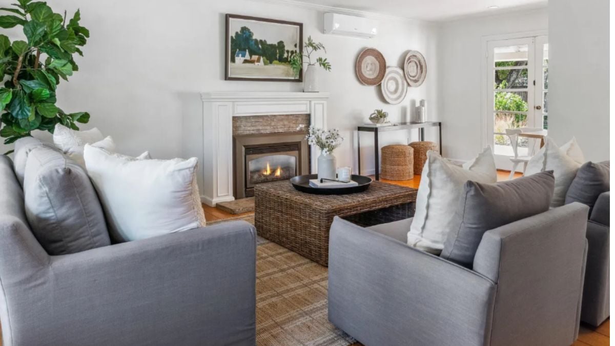 A living room with a fireplace, painting, couches, and a center table.