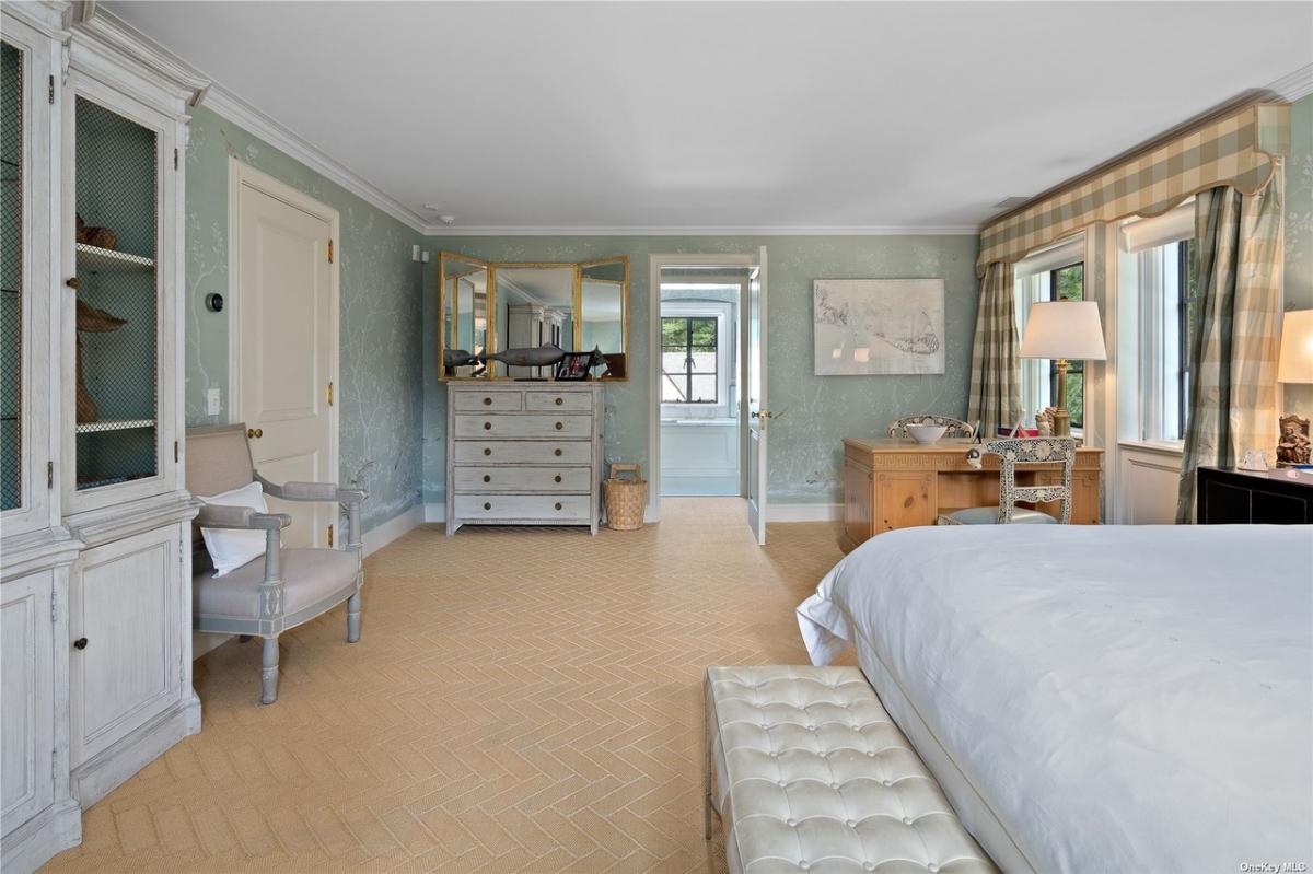 Bedroom with a large bed and carpet flooring.