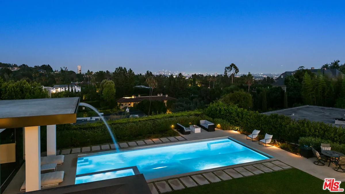 Pool with lounge chairs and a fire pit.