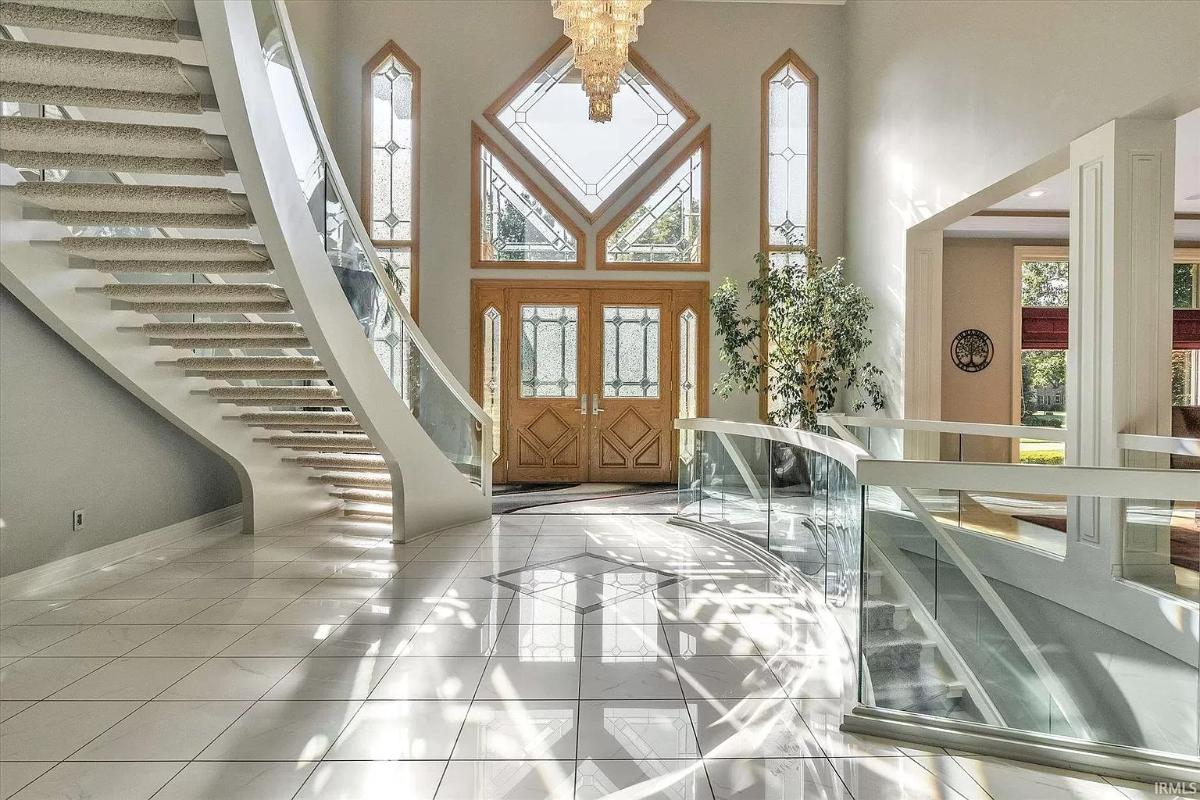 Foyer with custom made chandelier and curved glass staircase.