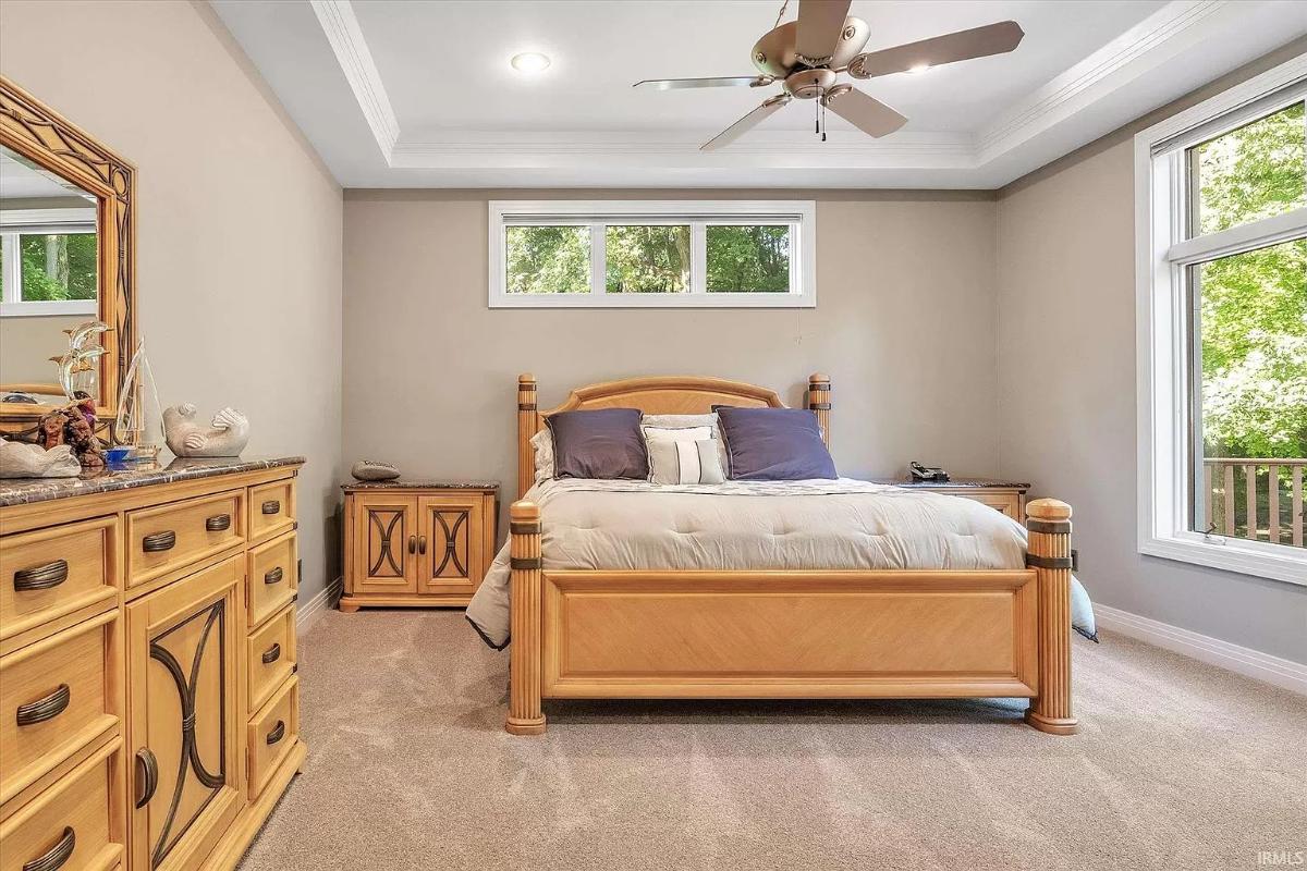 Bedroom with carpet flooring and glass windows.