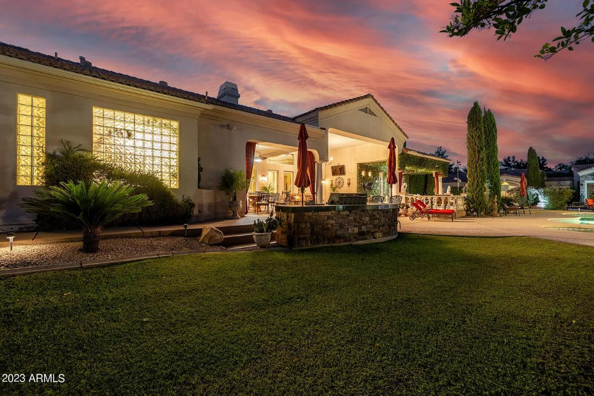 Rear view of the mansion with a grill area and a pool.