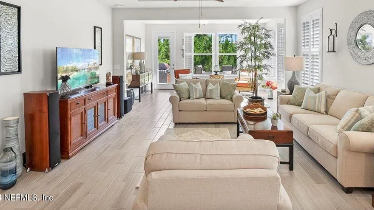 A family room with a TV, cabinet, couches, and a center table.