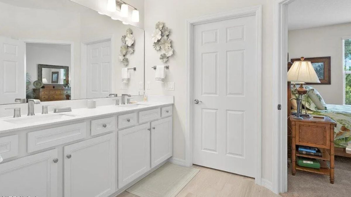 A bathroom with dual vanities and a mirror.