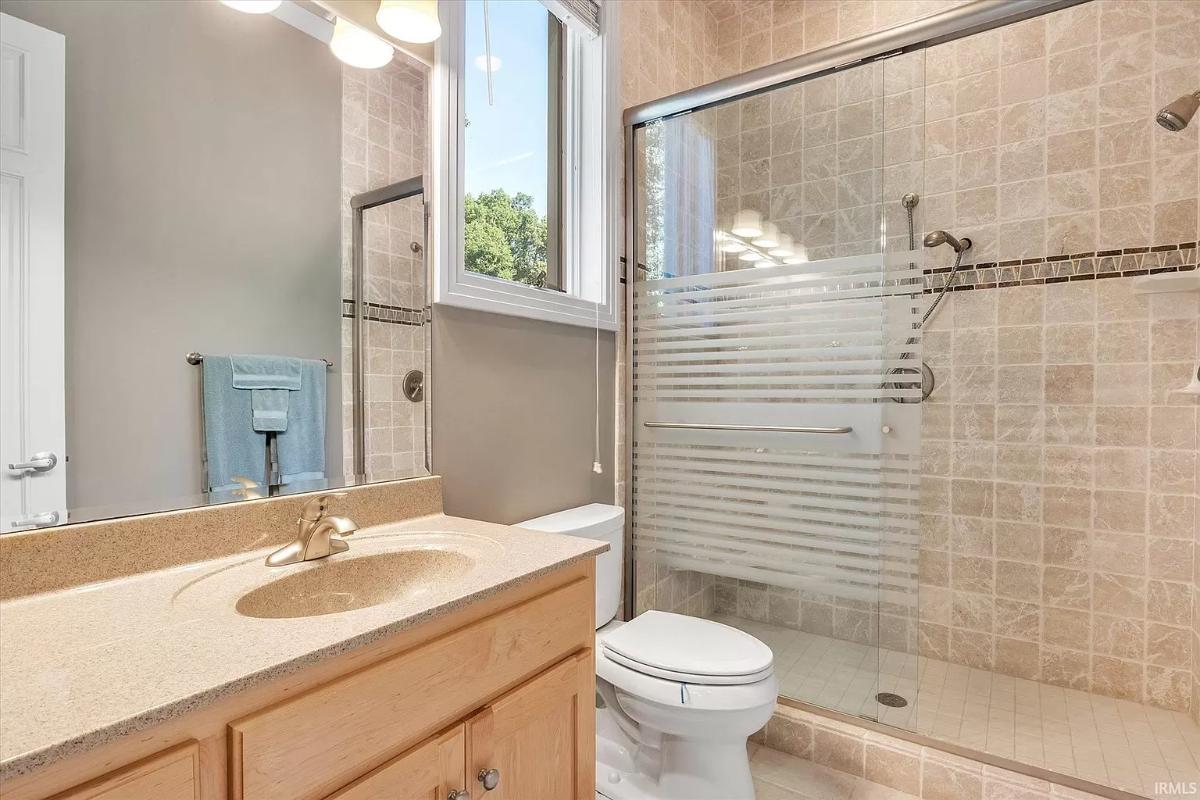 Bathroom with a sink, toilet and a walk-in shower.