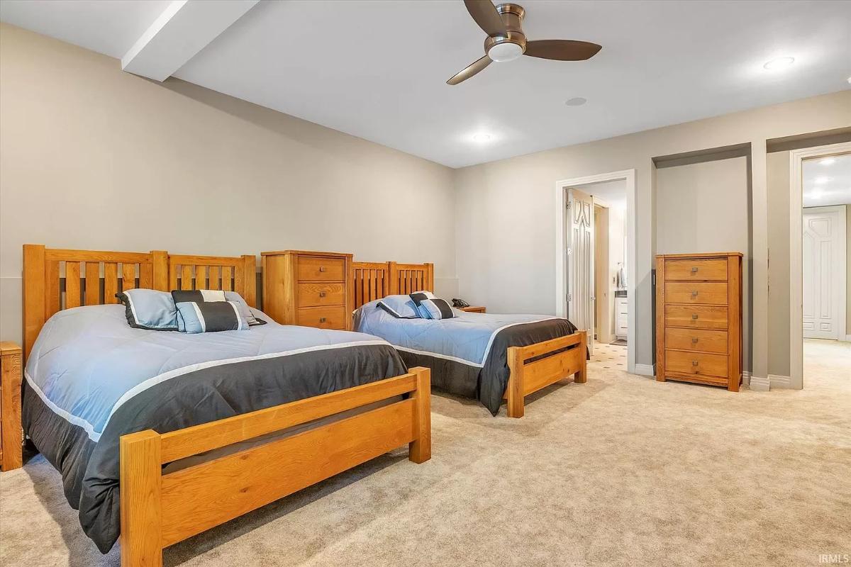 Bedroom with carpet flooring and two beds.