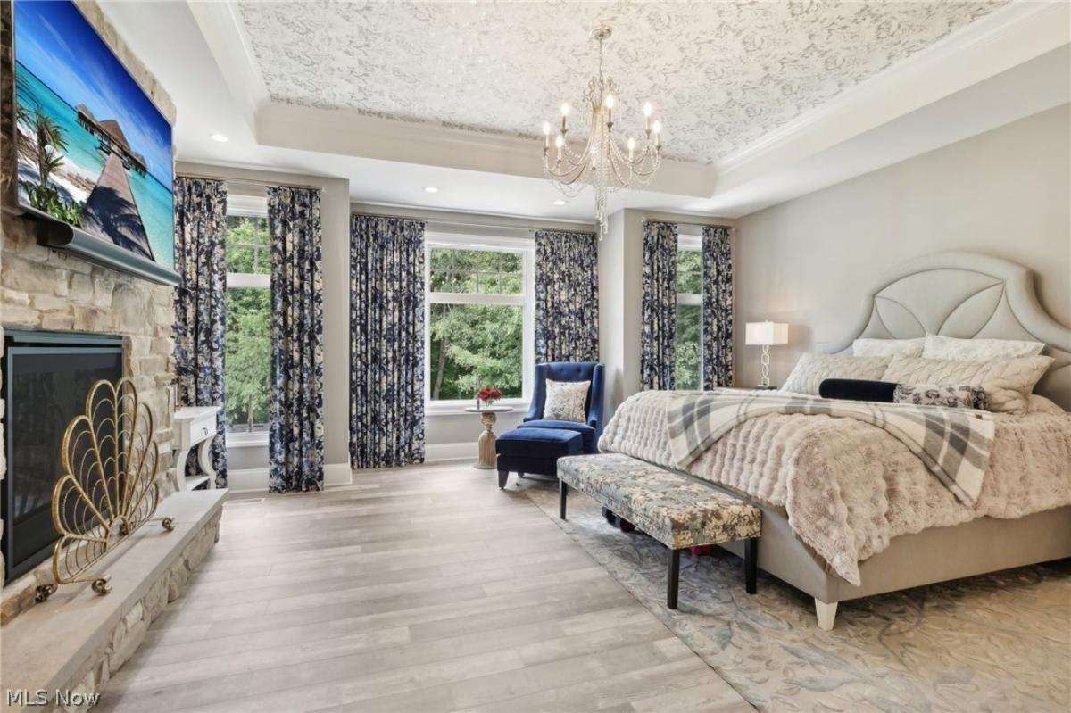 Bedroom with a chandelier and a fireplace.