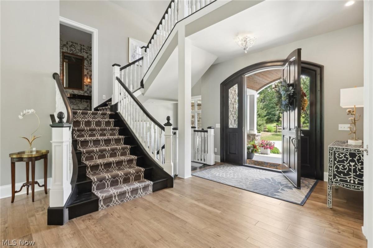Foyer with a hardwood door and stairs.