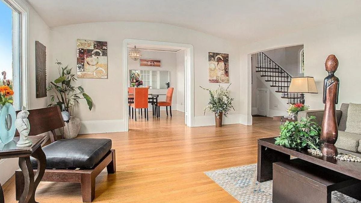 A living room with paintings, a chair, a couch, and a coffee table.