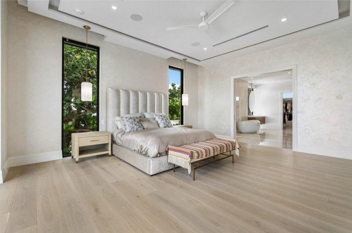 Bedroom with hardwood floors and a private bathroom.