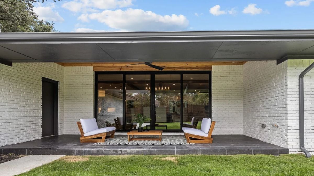 A porch with a rug, chairs, and a center table.