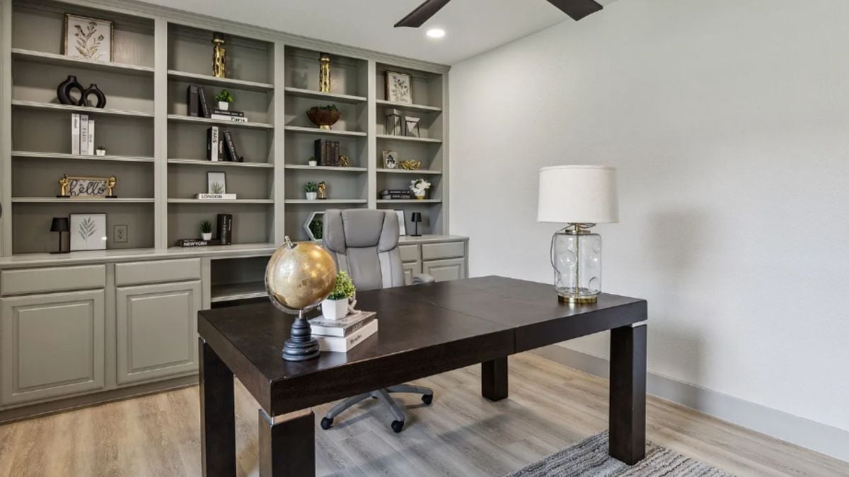 A home office with a shelf and a desk with an office chair.