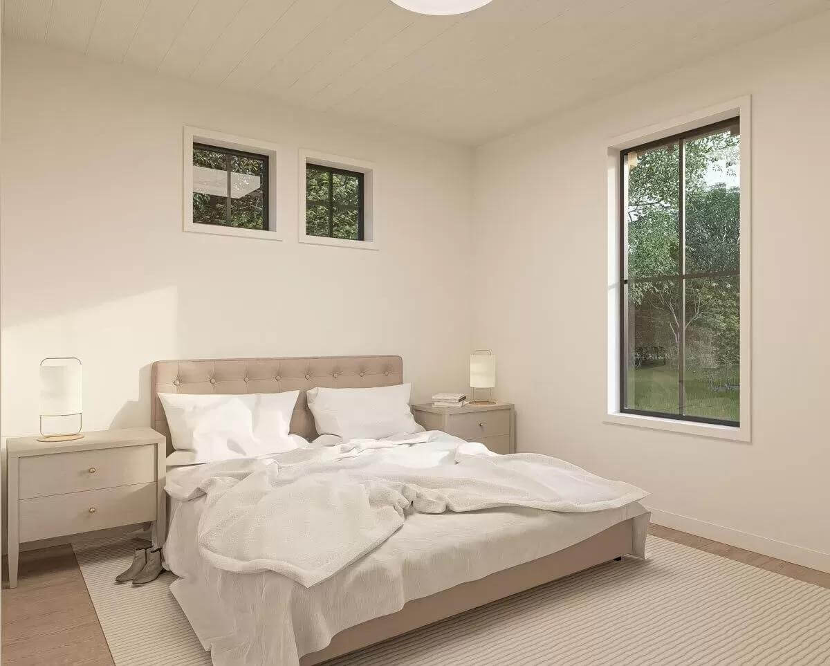 Primary bedroom with a tufted bed topped by clerestory windows.