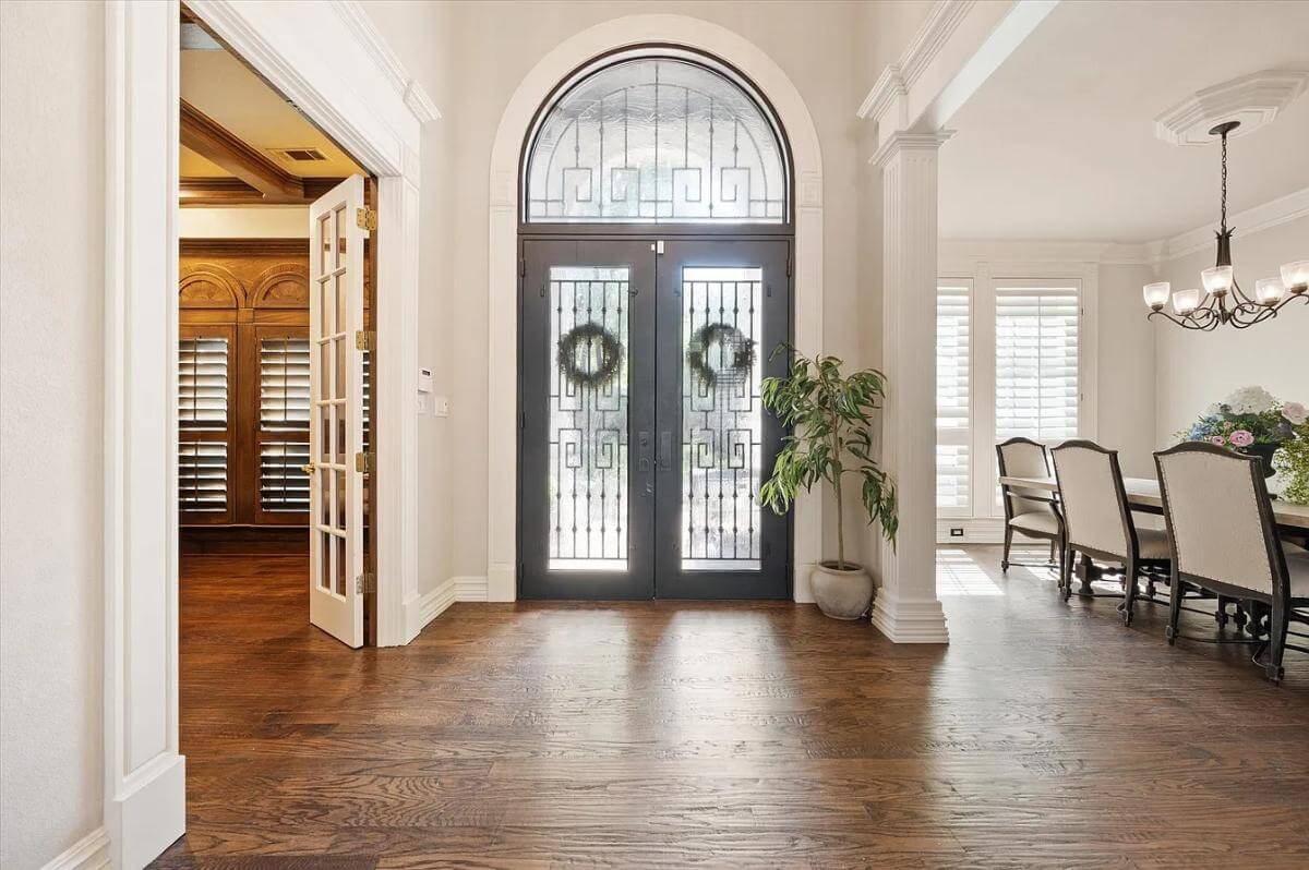 Foyer with a French front door topped by an arched transom.