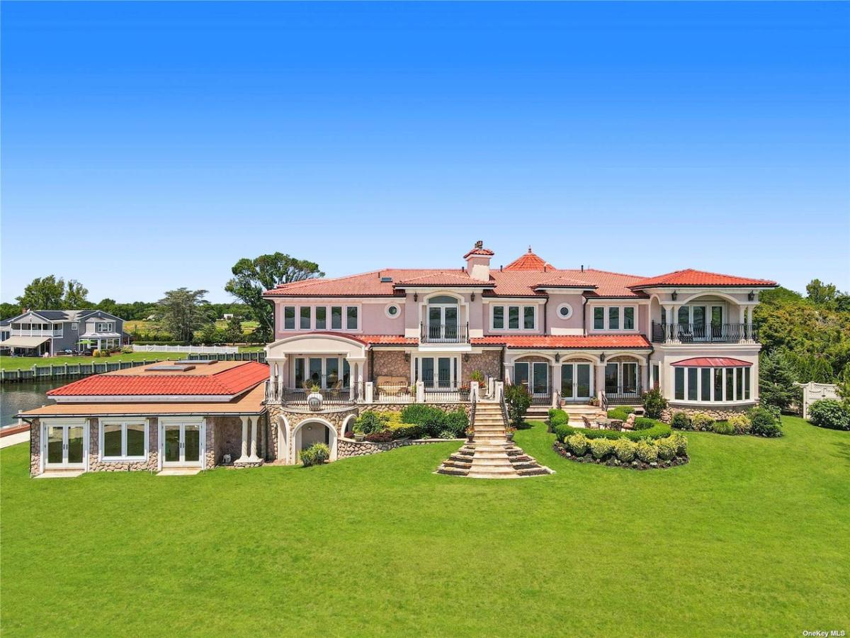Rear view of the mansion with a huge green lawn.