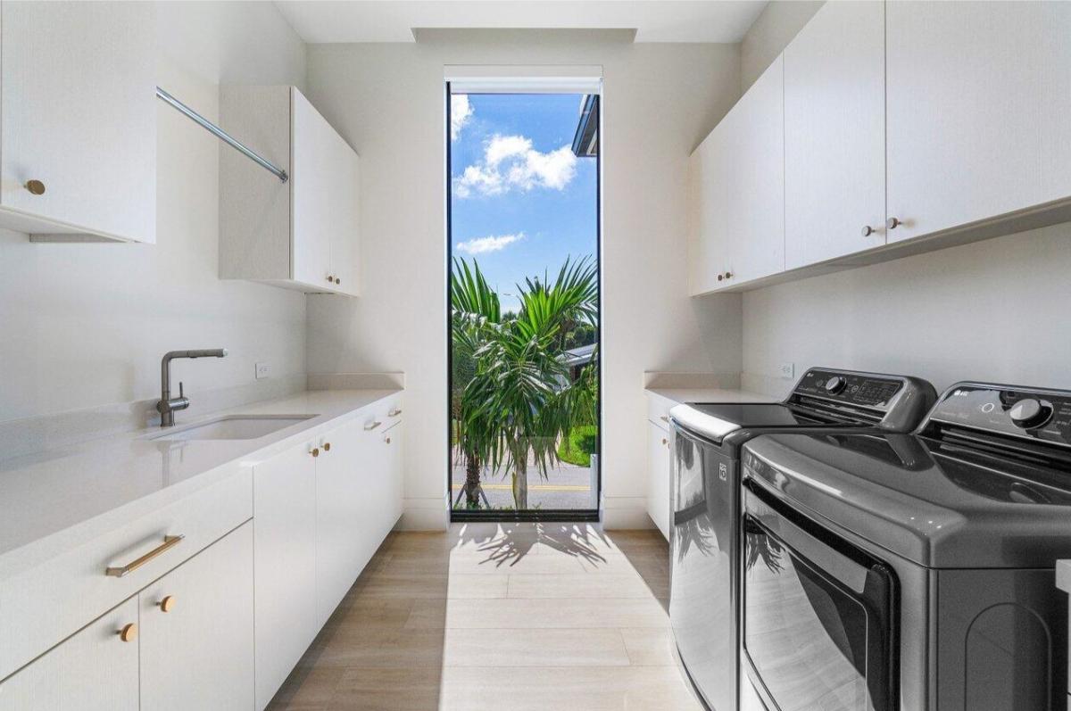 Laundry room with a sink and cabinets.