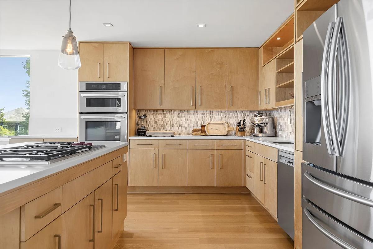 Kitchen with a custom cabinetry, stainless-steel appliances and a center island prep area.