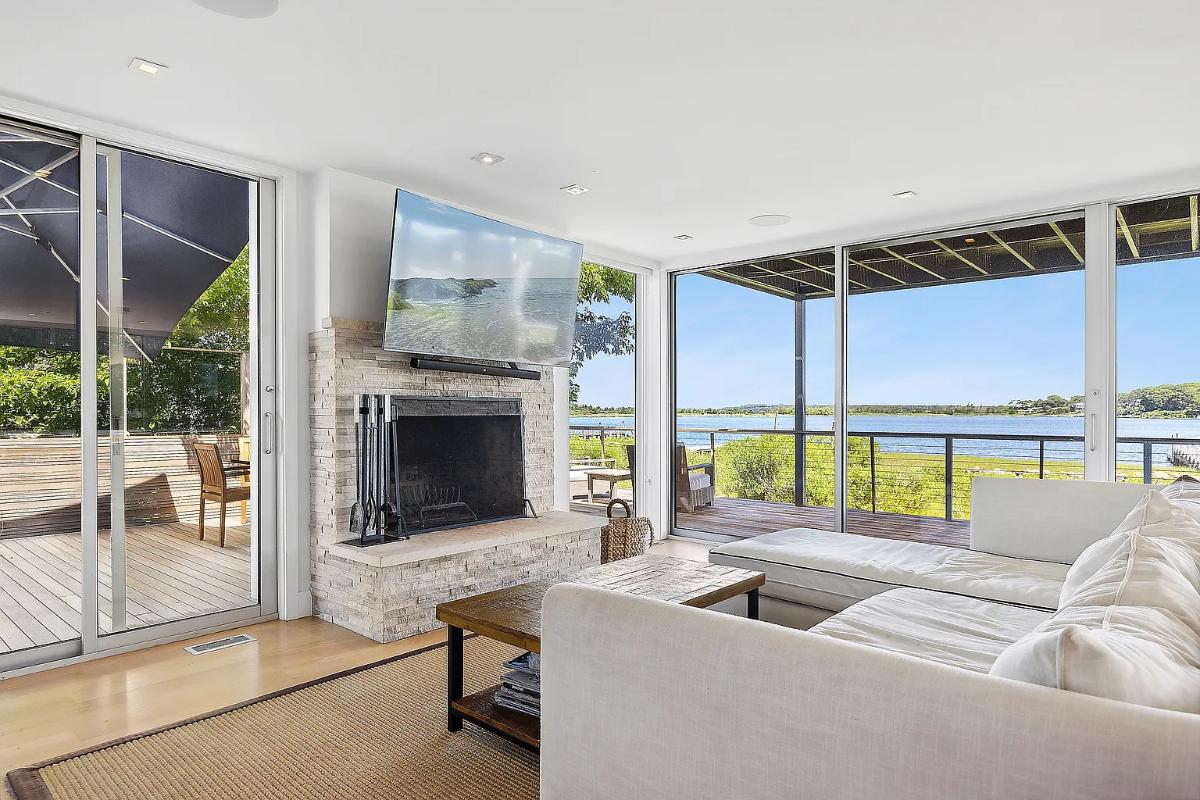 Living room with couches, a fireplace and sliding glass doors.