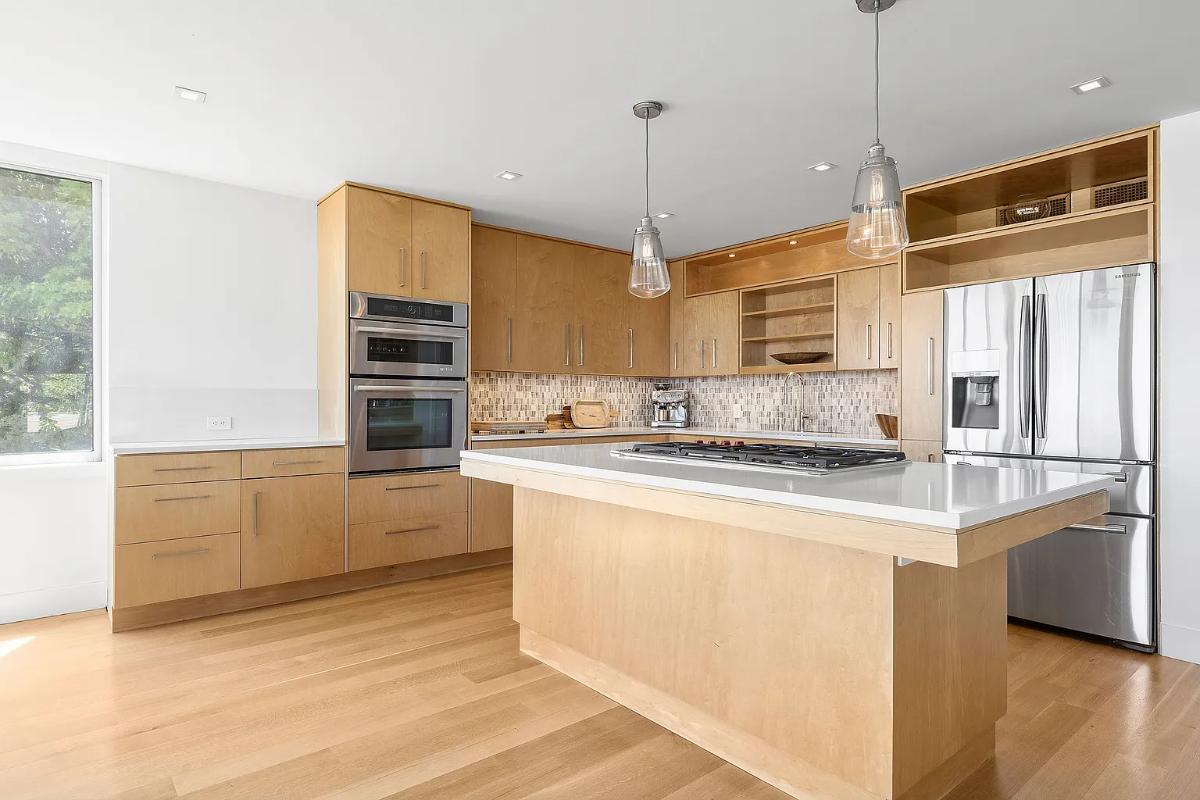 Kitchen with a custom cabinetry, stainless-steel appliances and a center island prep area.