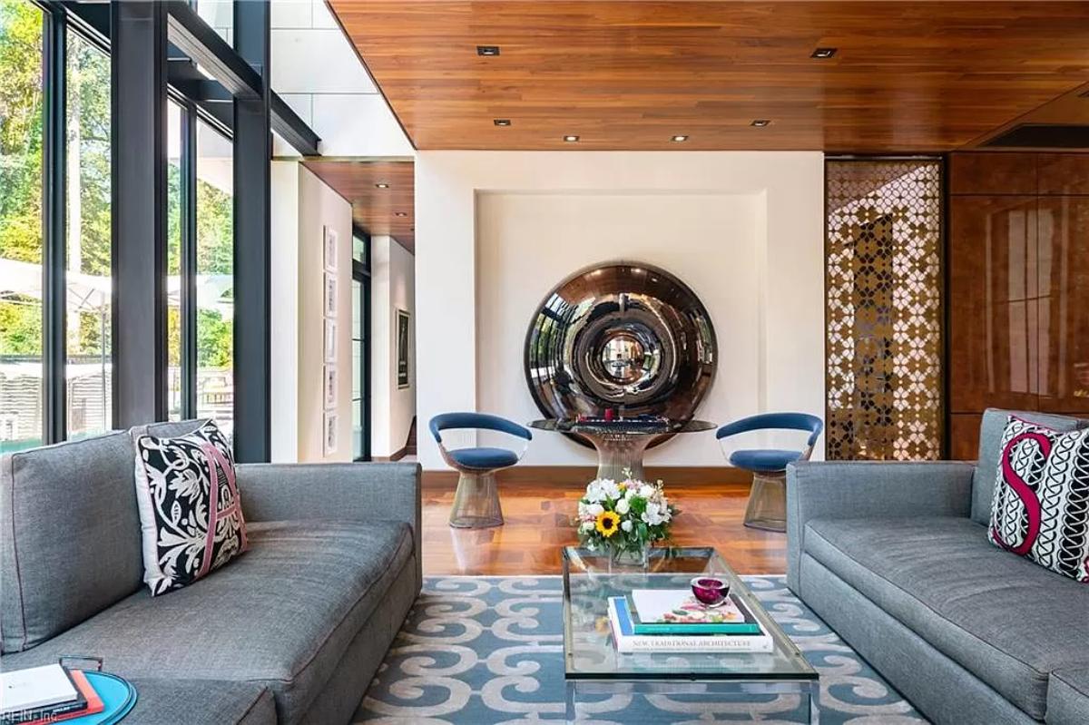 Living room with couches and hardwood floors.