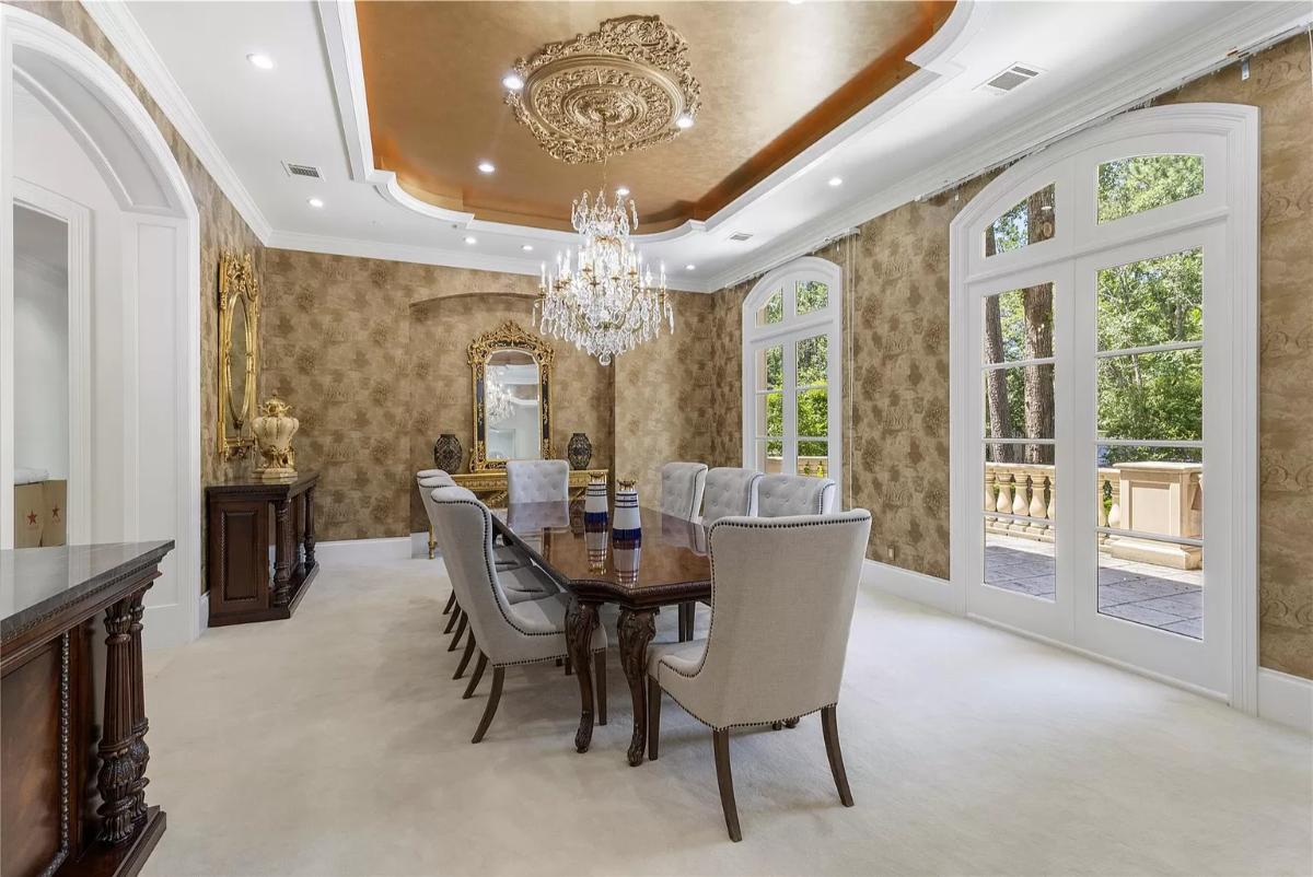 Dining room with carpet flooring and a chandelier.