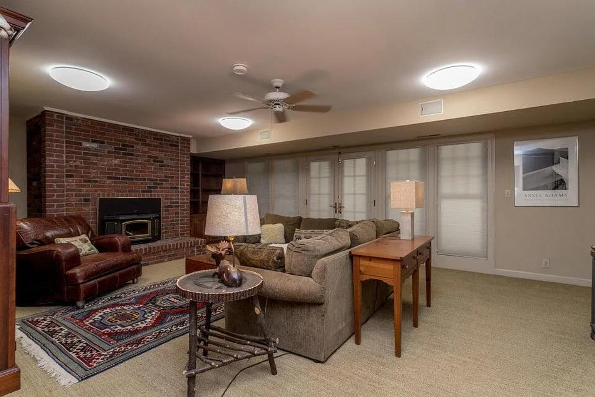 Living room with a fireplace and carpet flooring.