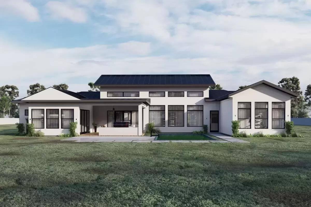 Rear view with a covered patio and a multitude of windows.