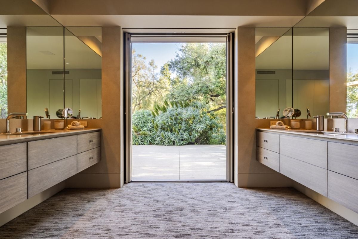A bathroom with vanities, cabinets, and mirrors.