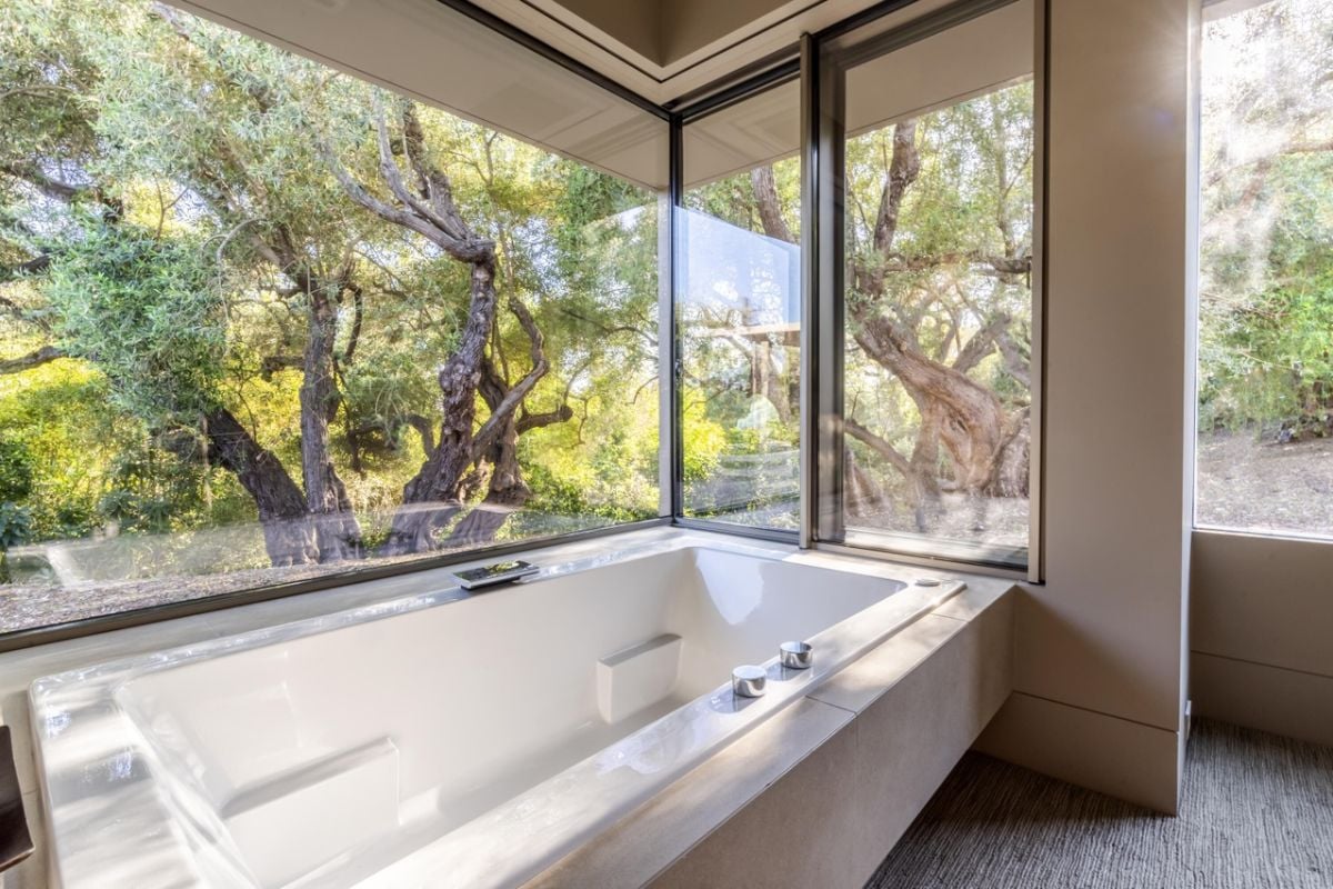 A bathroom with windows and a bathtub.
