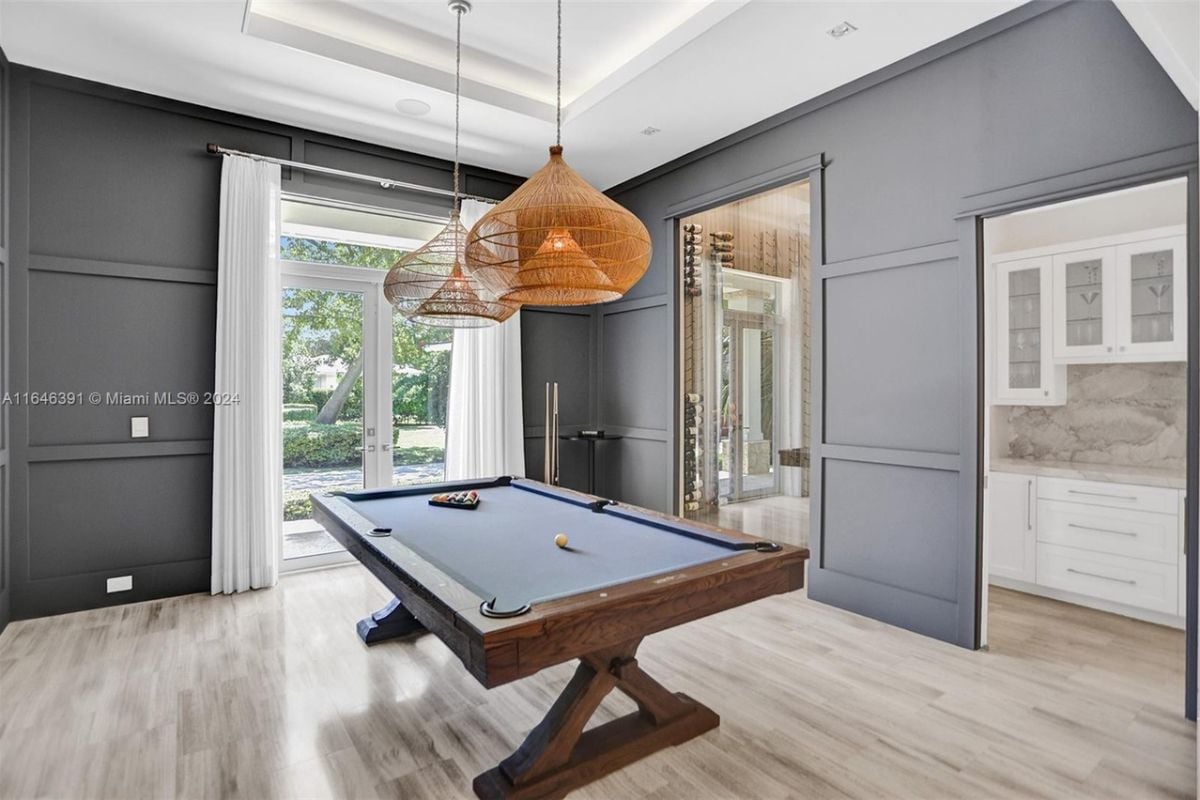 A game room with a pool table.