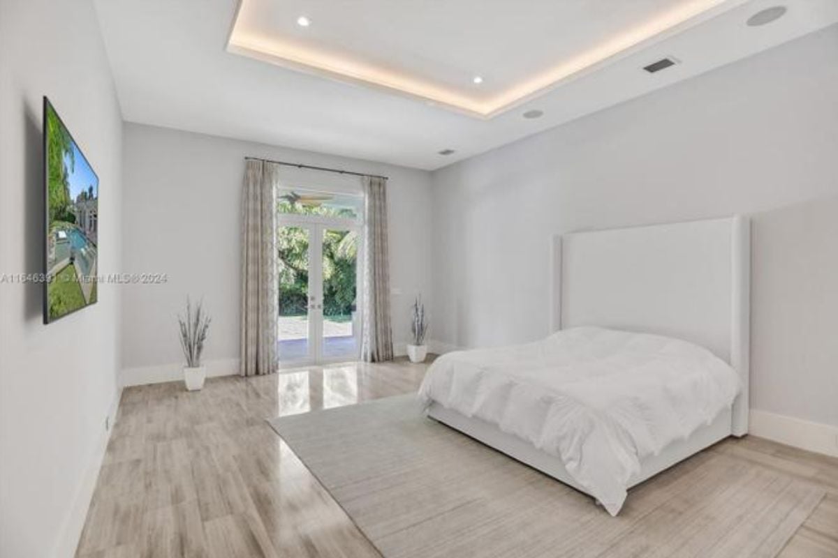 A bedroom with a bed, rug, and TV.