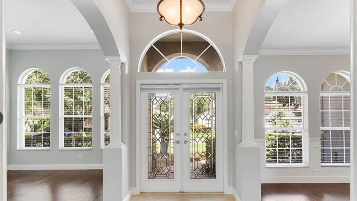A foyer with a chandelier and windows.