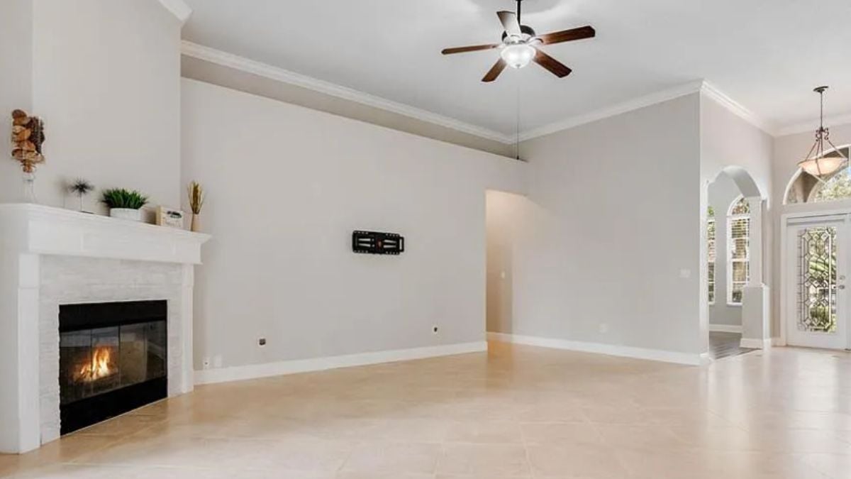 A family room with a ceiling fan and a fireplace.