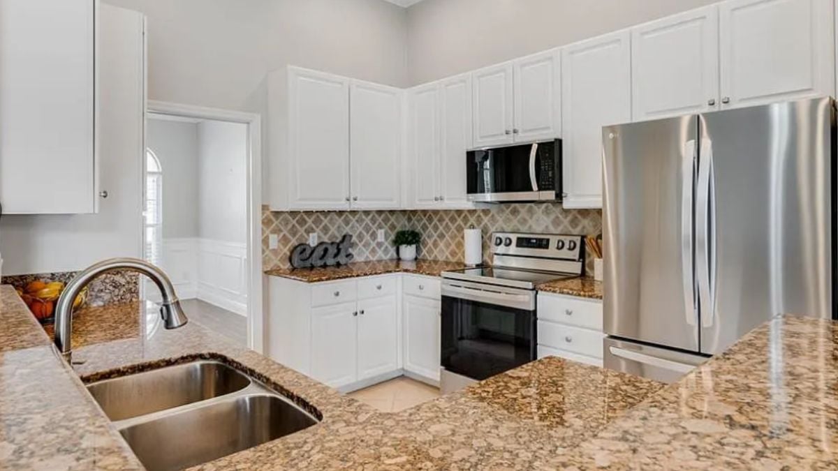 A kitchen with countertops, a sink, cabinets, and kitchen appliances.