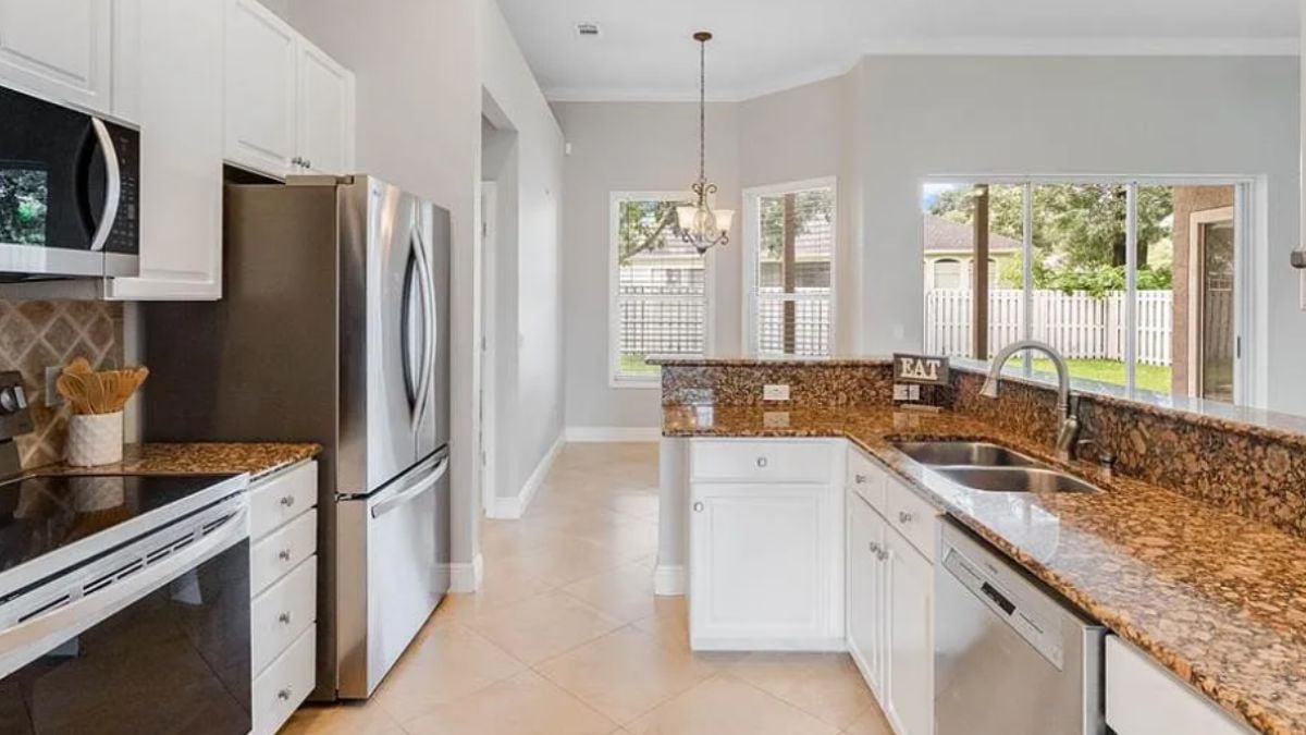 A kitchen with countertops, a sink, cabinets, and kitchen appliances.