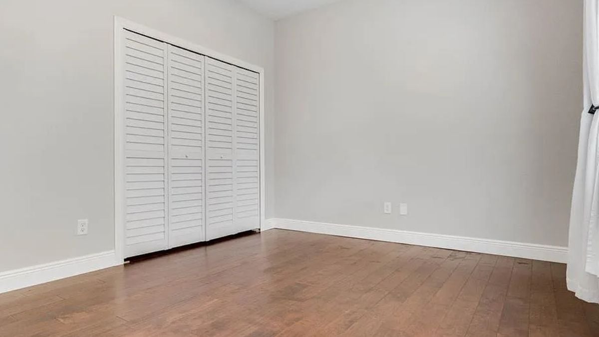 A bedroom with a wooden floor.