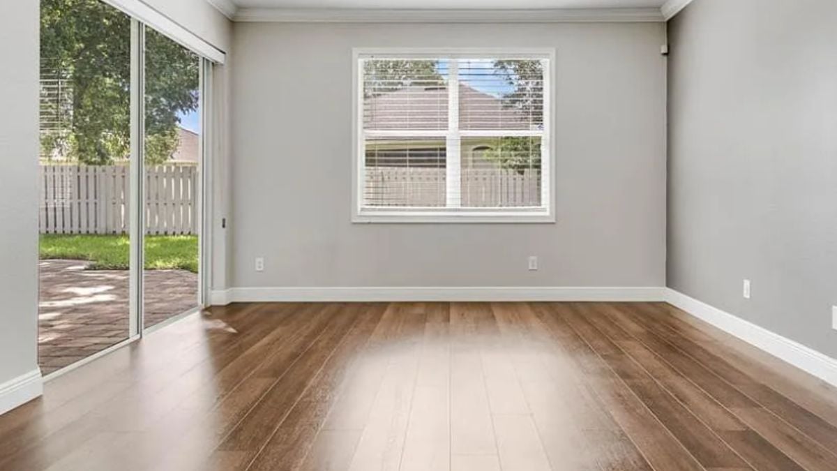 A bedroom with a wooden floor and a window.