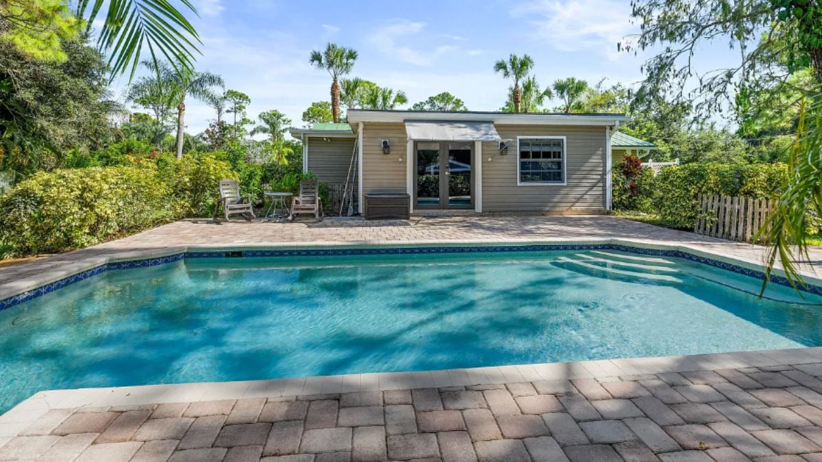 A swimming pool surrounded by plants and trees.