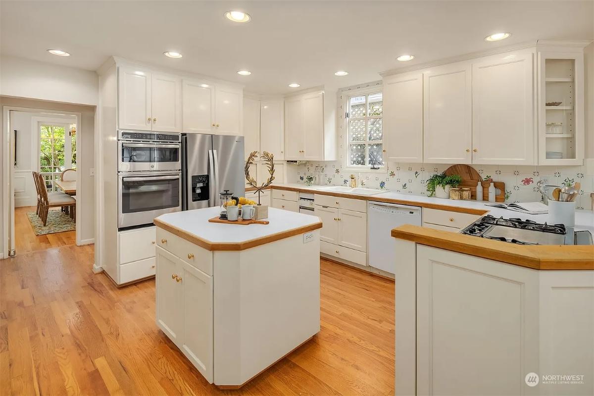 Kitchen with a custom cabinetry, stainless-steel appliances, and an island prep area.