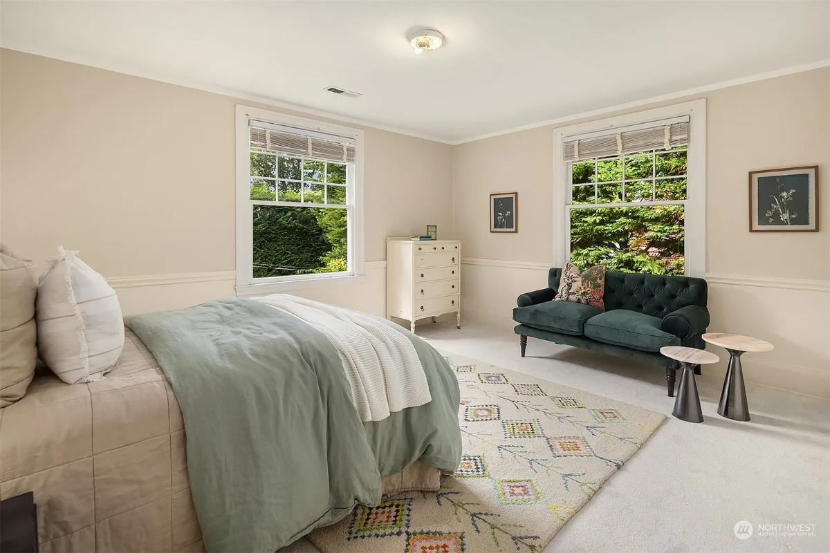 Bedroom with carpet flooring and glass windows.