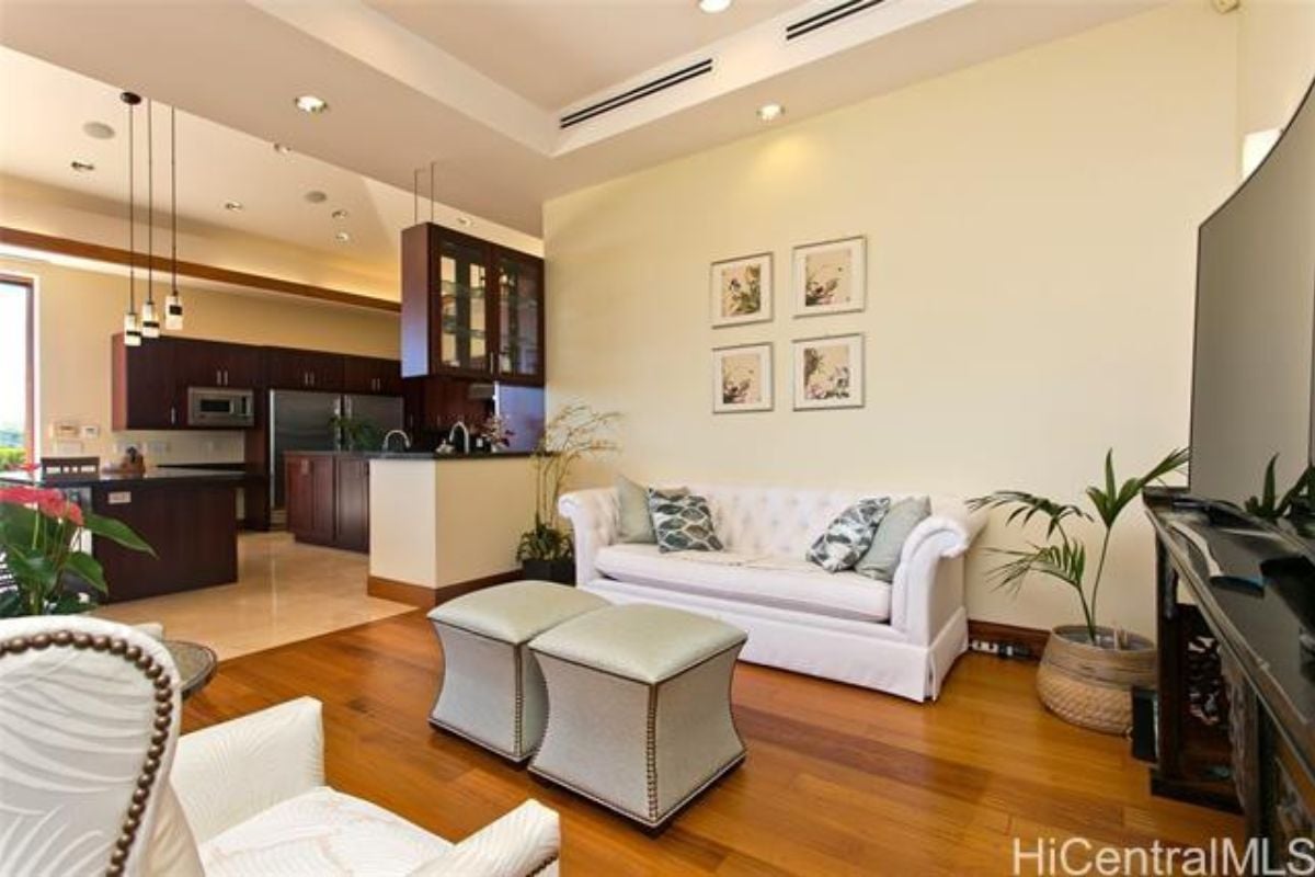 A living room with a TV, couch, chairs, and a coffee table.