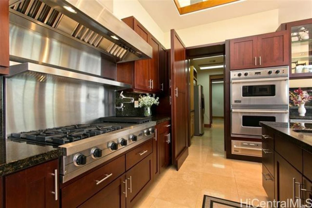 A kitchen with countertops, cabinets, a sink, and kitchen appliances.