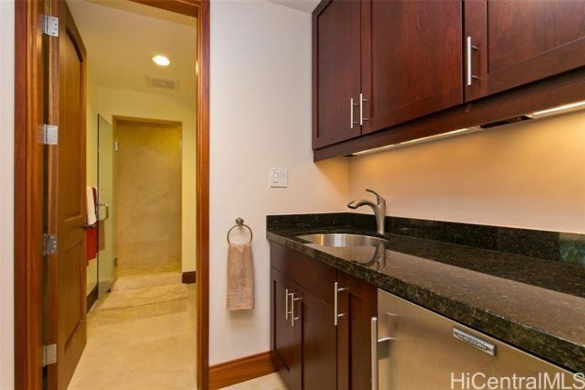 A kitchen with a sink, countertop, and cabinet.