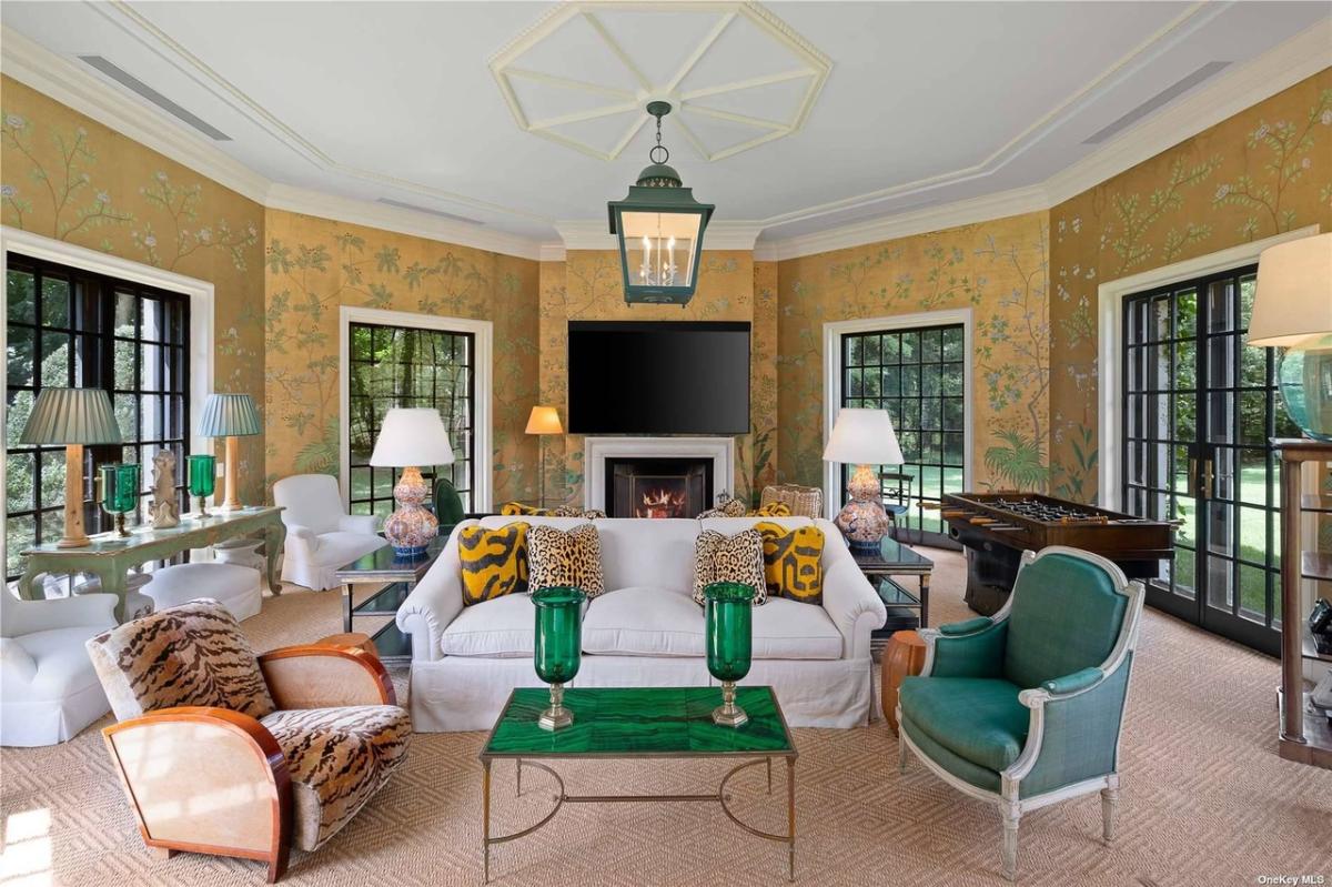 Living room with tables, couches and a fireplace.