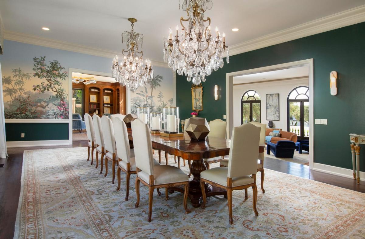 Dining room with a large wood table and chandeliers.