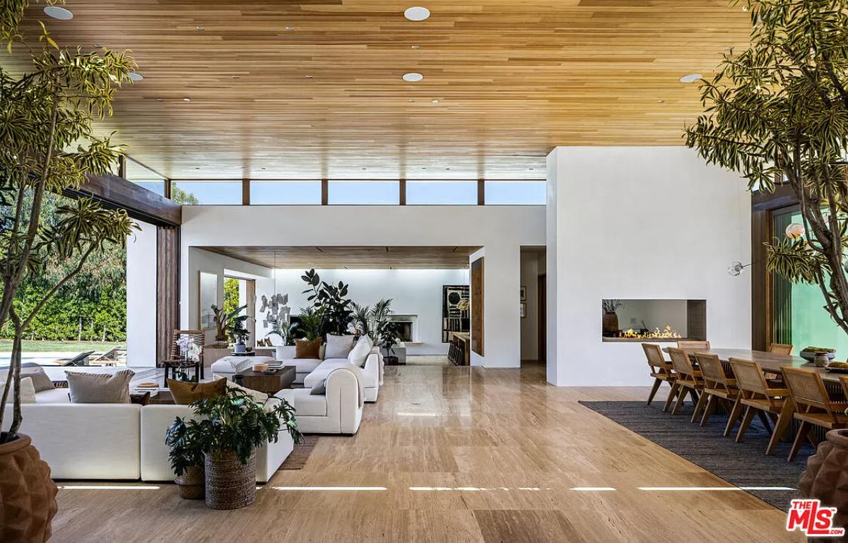 Living room with couches and hardwood floors.