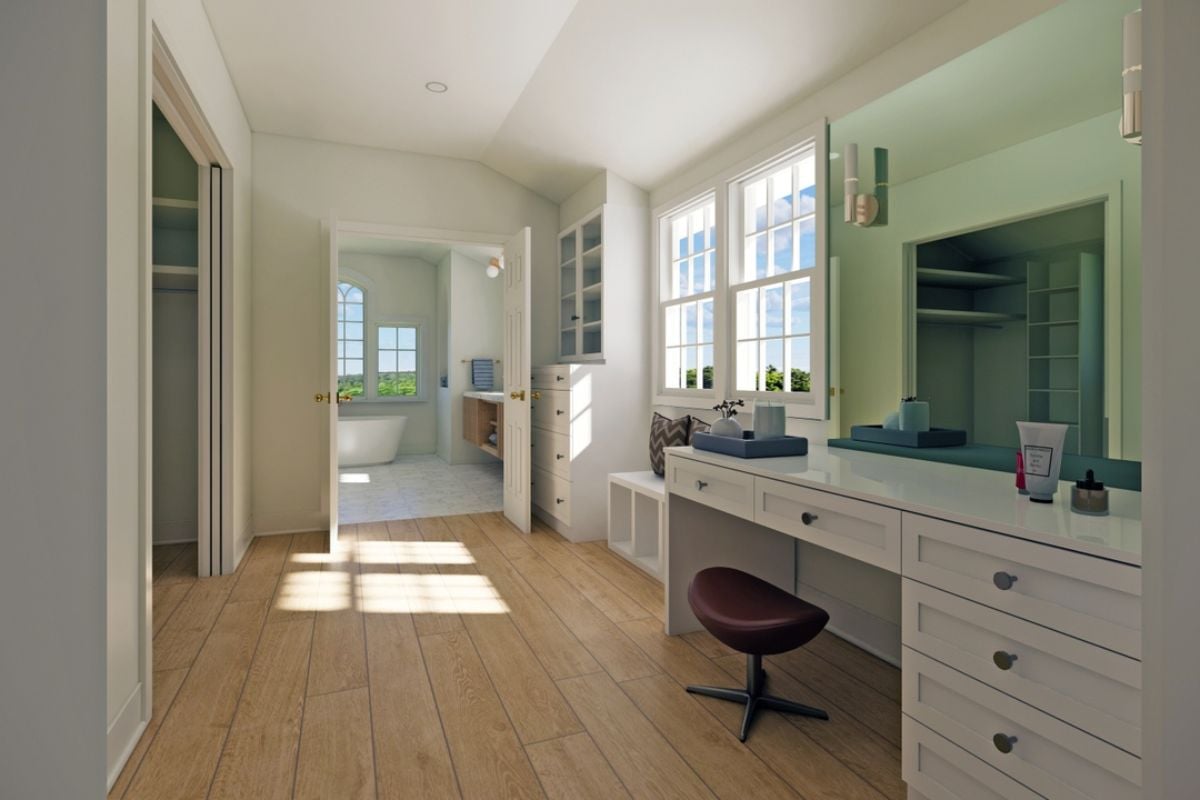 A powder room with a desk with drawers, a mirror, a chair, and windows.