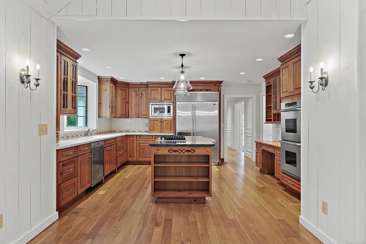 Kitchen with custom cabinetry, stainless-steel appliances and a center island prep area.